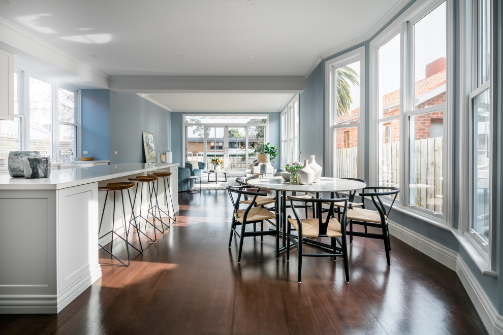 Стильный дизайн: маленькая гостиная-столовая в современном стиле с синими стенами, темным паркетным полом и коричневым полом для на участке и в саду - последний тренд