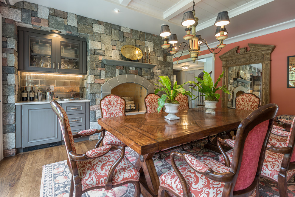 Inspiration for a large timeless medium tone wood floor kitchen/dining room combo remodel in Milwaukee with multicolored walls, a standard fireplace and a stone fireplace