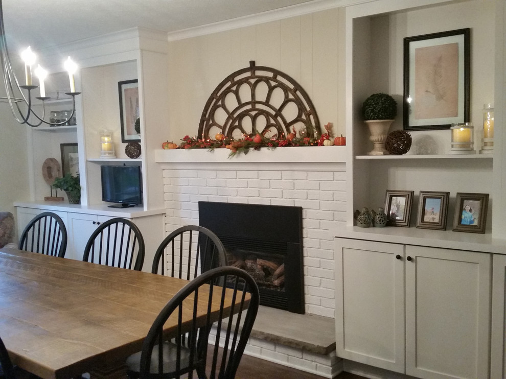 Medium sized farmhouse enclosed dining room in Other with beige walls, a standard fireplace, a brick fireplace surround, brown floors and vinyl flooring.