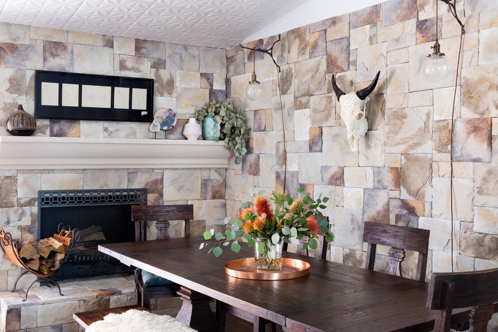 Aménagement d'une salle à manger campagne avec un mur multicolore, une cheminée standard et un manteau de cheminée en pierre.