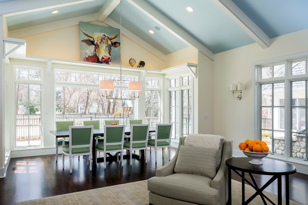 Immagine di una grande sala da pranzo aperta verso il soggiorno tradizionale con pareti beige, parquet scuro e pavimento marrone