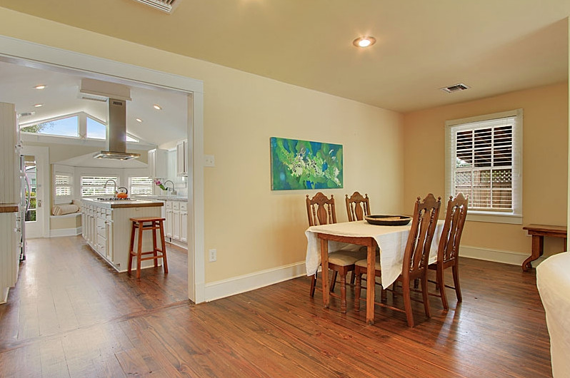 Photo of a medium sized traditional open plan dining room in New Orleans with yellow walls, medium hardwood flooring and no fireplace.