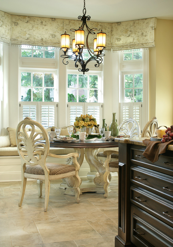 Ispirazione per una sala da pranzo aperta verso la cucina classica con pareti beige e pavimento in travertino