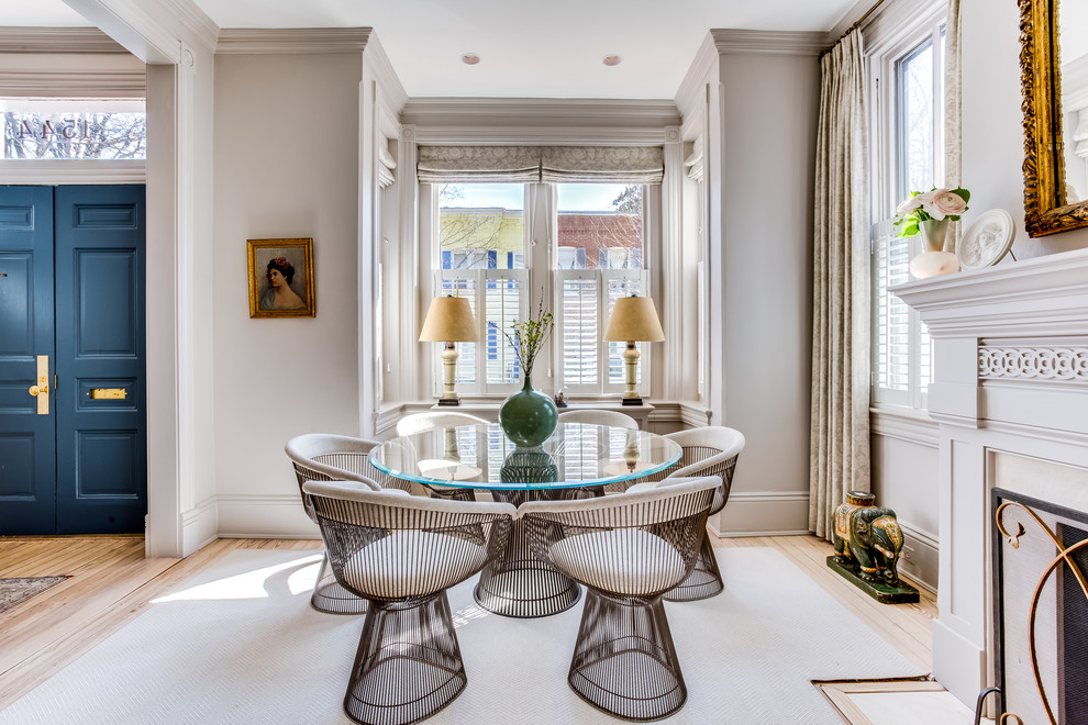 This is an example of a medium sized traditional open plan dining room in DC Metro with grey walls, light hardwood flooring, a standard fireplace, beige floors and a plastered fireplace surround.