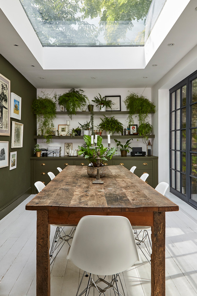 На фото: столовая в стиле неоклассика (современная классика) с зелеными стенами, деревянным полом и белым полом с