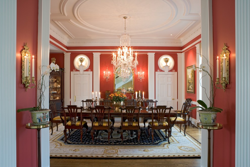 Exemple d'une salle à manger chic avec un mur rouge, un sol en bois brun et un sol marron.