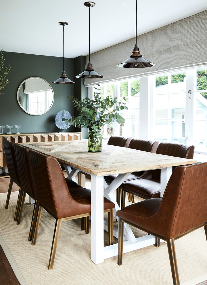 Foto di una sala da pranzo design con pareti verdi e pavimento marrone