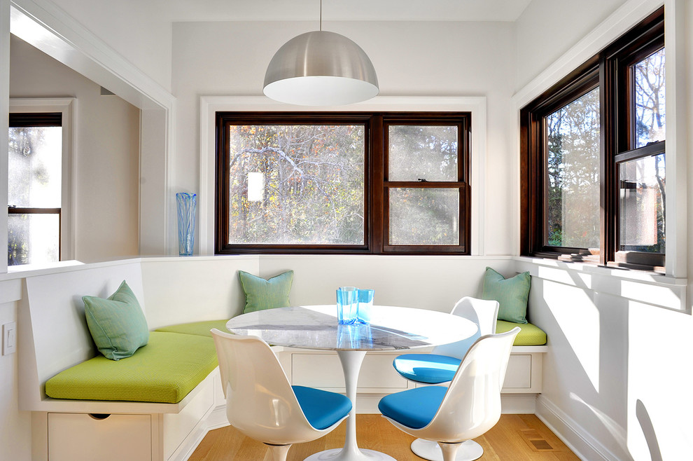 Klassische Wohnküche ohne Kamin mit weißer Wandfarbe und braunem Holzboden in New York