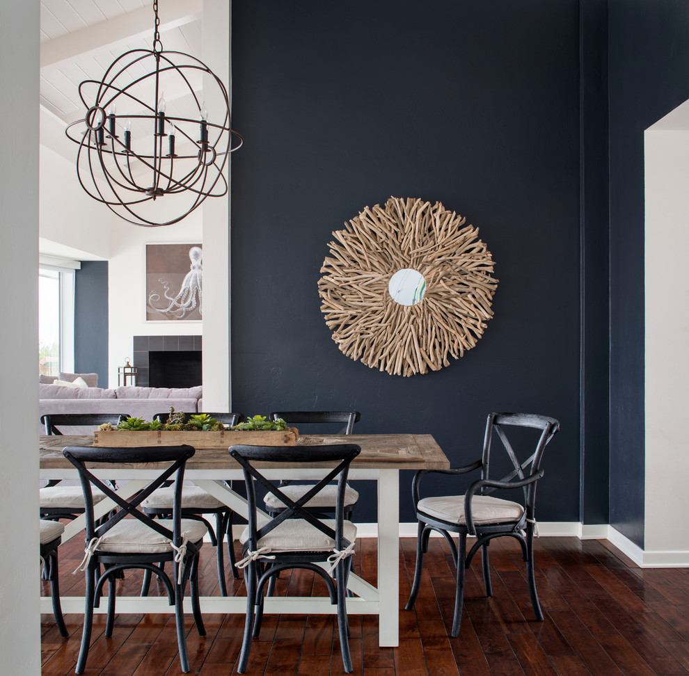 Immagine di una grande sala da pranzo aperta verso la cucina stile marinaro con parquet scuro e pareti blu