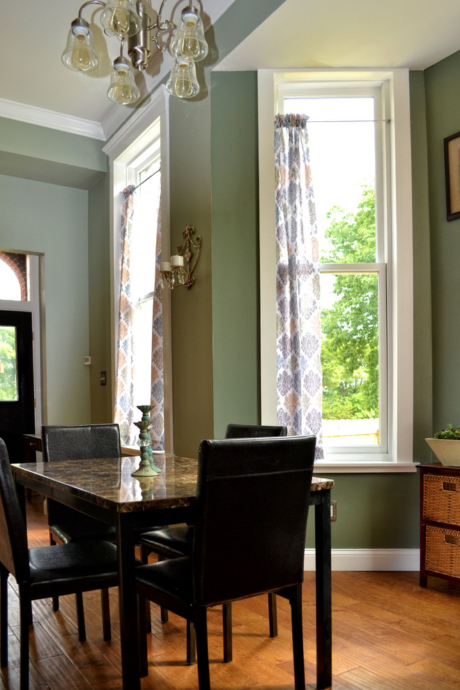 Immagine di una piccola sala da pranzo aperta verso la cucina tradizionale con pareti verdi, pavimento in legno massello medio, nessun camino e pavimento verde