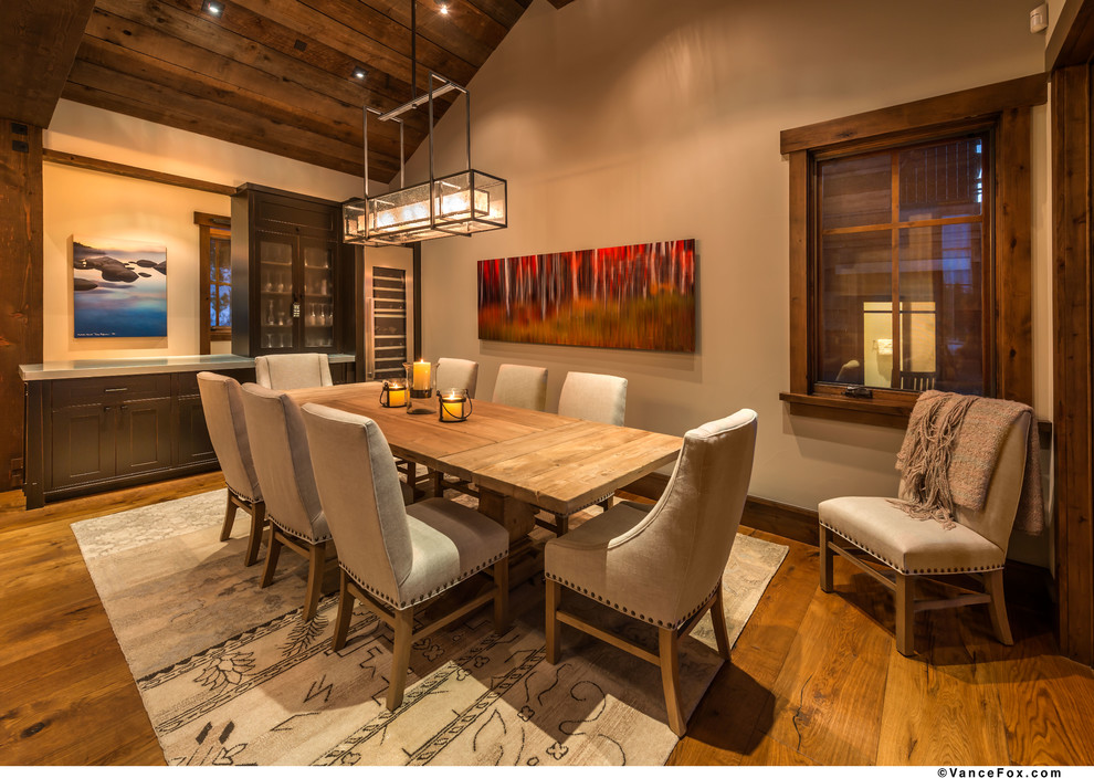 Cette image montre une salle à manger ouverte sur le salon chalet de taille moyenne avec un sol en bois brun.