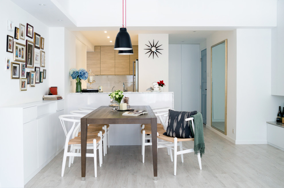 Aménagement d'une salle à manger ouverte sur la cuisine moderne avec un mur blanc.