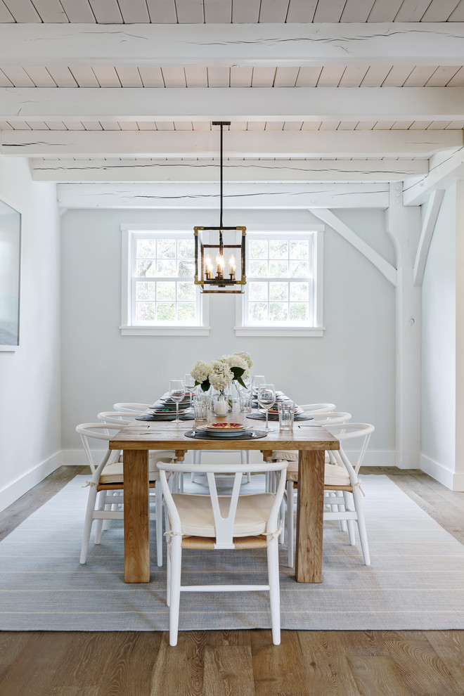 Cette photo montre une salle à manger bord de mer avec un mur blanc, parquet clair et aucune cheminée.