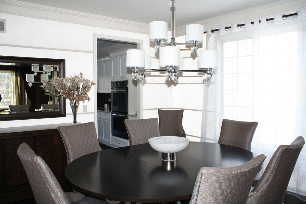 This is an example of a medium sized modern enclosed dining room in Chicago with white walls, dark hardwood flooring, no fireplace and black floors.
