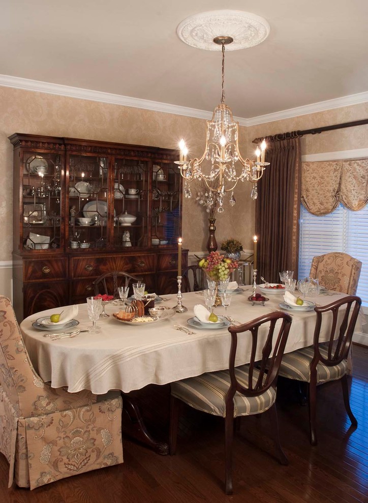 Cette image montre une salle à manger traditionnelle avec un mur beige et parquet foncé.