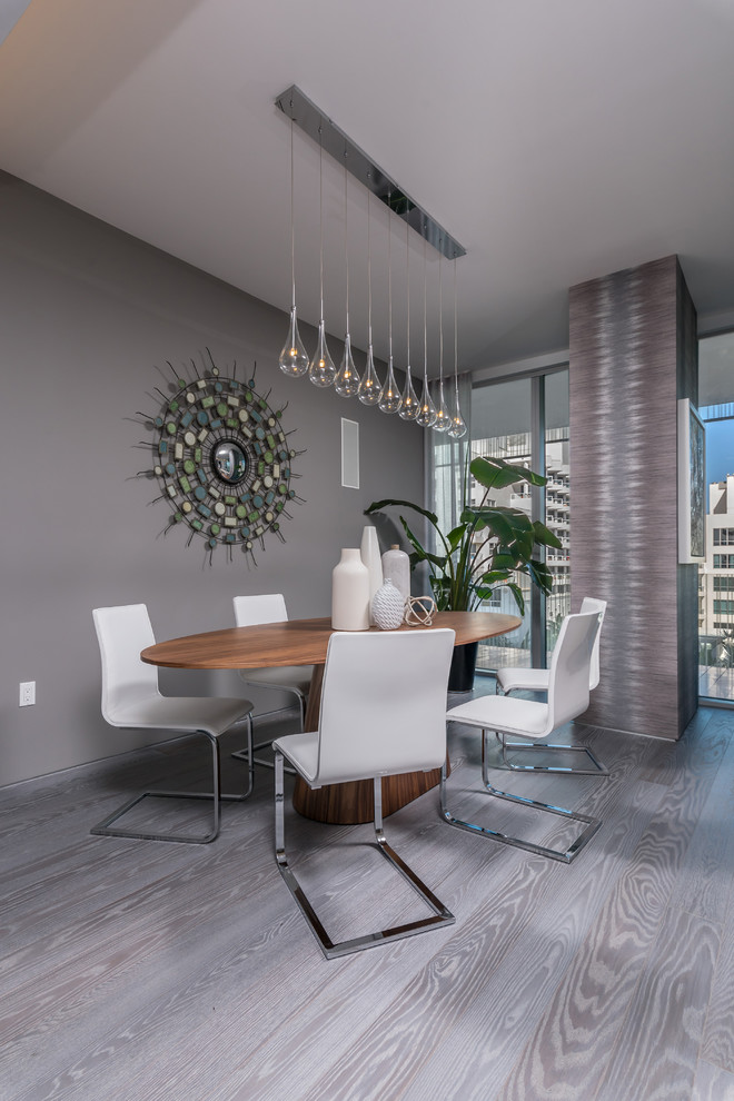 Contemporary dining room in Miami with grey walls and grey floors.
