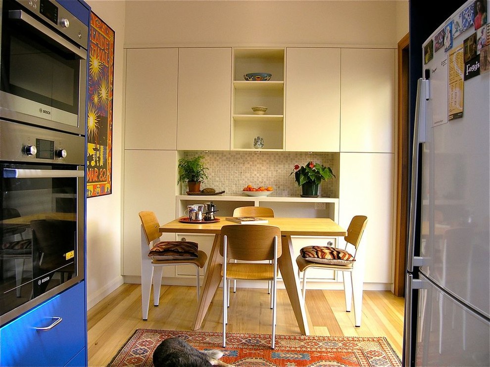 Imagen de comedor de cocina actual pequeño con paredes blancas, suelo de madera clara y suelo multicolor