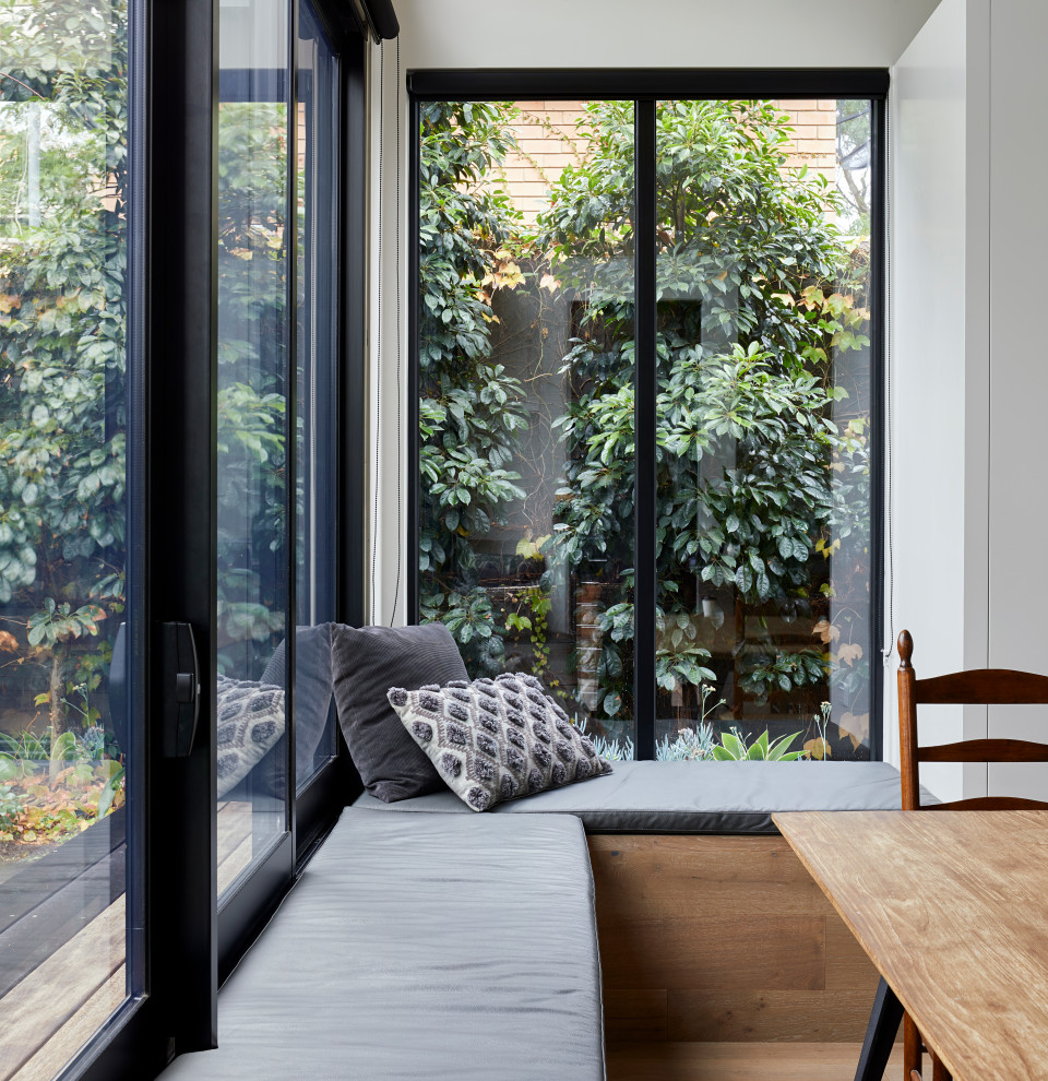 Große Moderne Wohnküche mit weißer Wandfarbe, hellem Holzboden und braunem Boden in Melbourne
