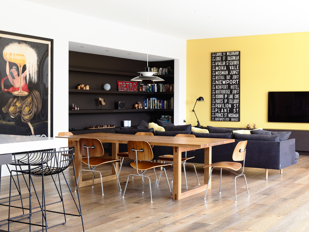 Diseño de comedor contemporáneo de tamaño medio abierto con paredes amarillas y suelo de madera en tonos medios