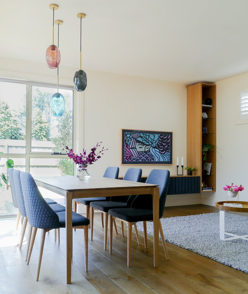 Ispirazione per una sala da pranzo aperta verso il soggiorno design con pareti beige, pavimento in legno massello medio e pavimento marrone