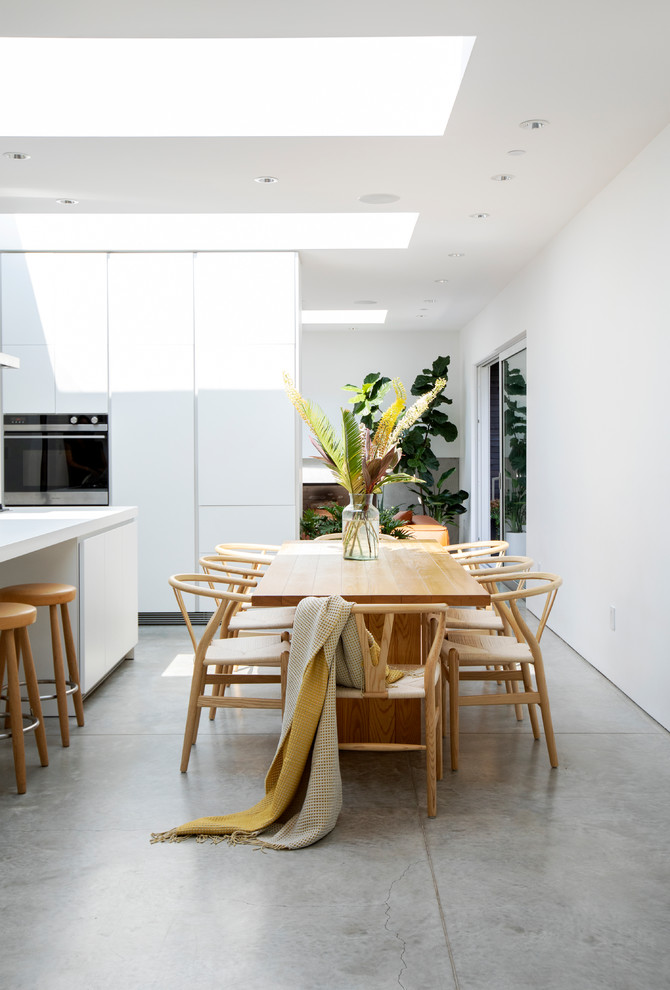 Inspiration for a mid-sized contemporary concrete floor and gray floor kitchen/dining room combo remodel in Vancouver with white walls and no fireplace