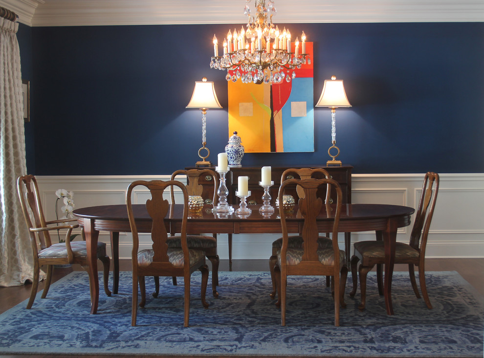 Foto di una sala da pranzo chic chiusa e di medie dimensioni con pareti blu, parquet scuro e pavimento marrone