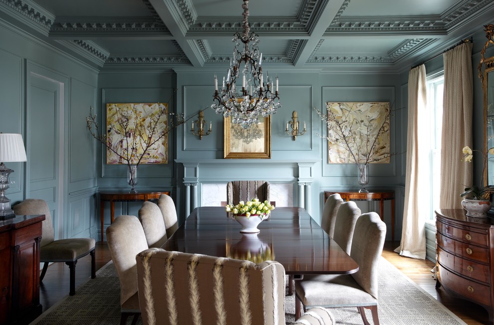 Inspiration for a mid-sized timeless medium tone wood floor enclosed dining room remodel in New York with blue walls and a standard fireplace