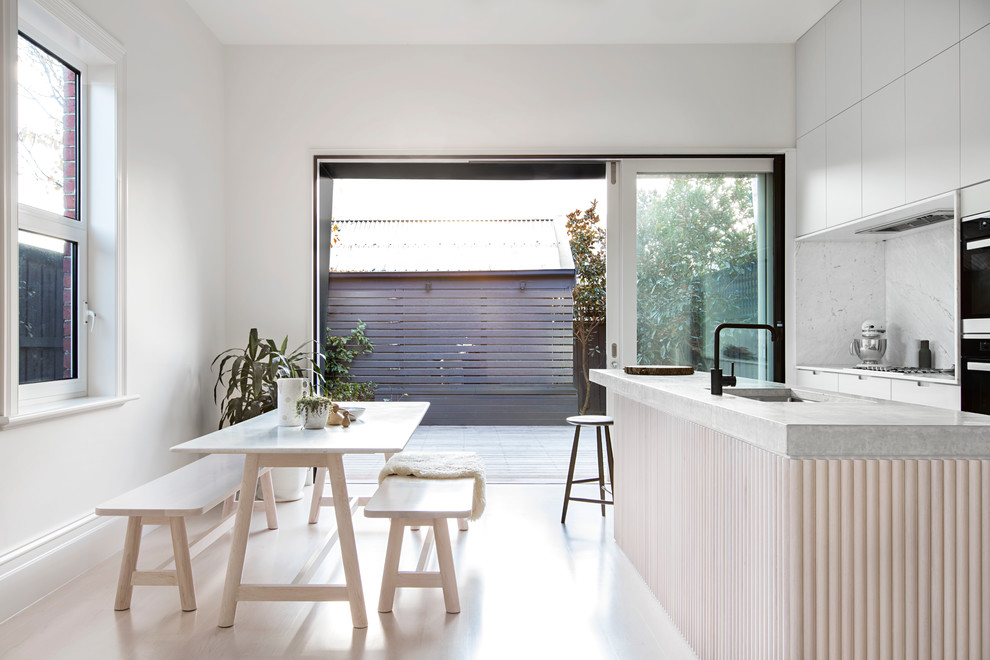 Skandinavische Wohnküche mit weißer Wandfarbe und hellem Holzboden in Melbourne
