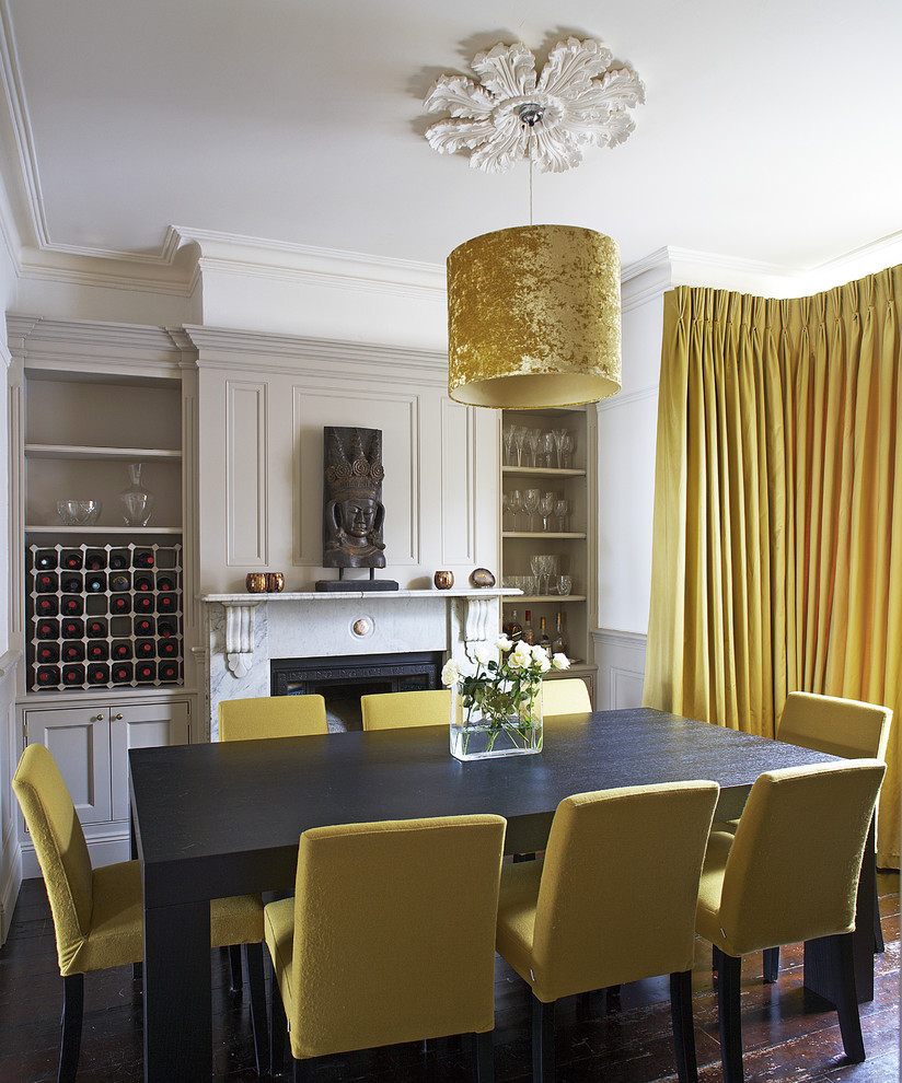 Trendy dark wood floor dining room photo in Dublin with white walls and a standard fireplace