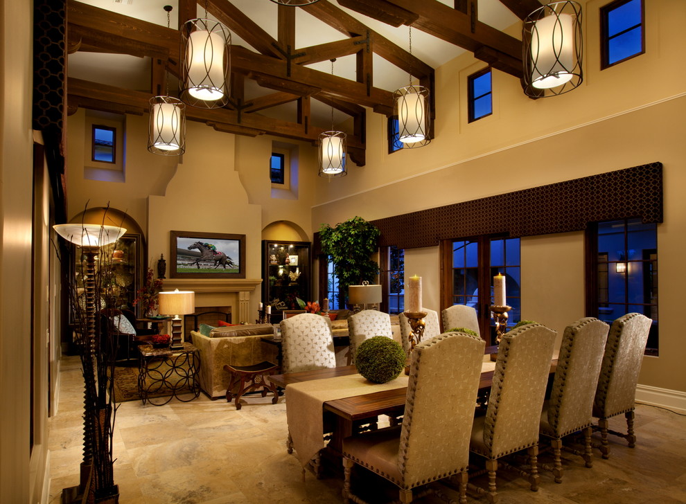Exemple d'une grande salle à manger ouverte sur le salon méditerranéenne avec un sol en travertin, une cheminée standard, un mur beige et éclairage.