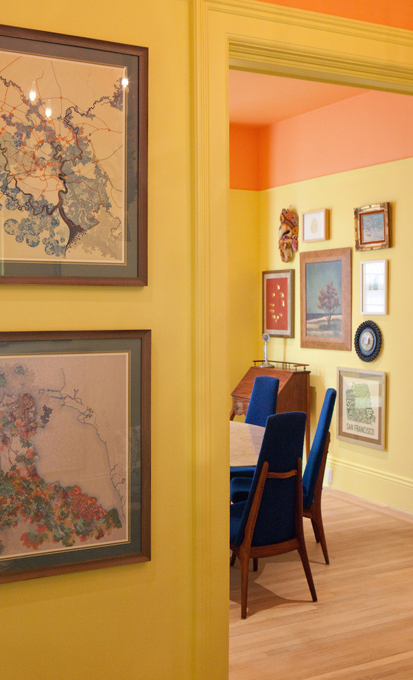 Ispirazione per una sala da pranzo classica chiusa e di medie dimensioni con pareti gialle, parquet chiaro e camino classico