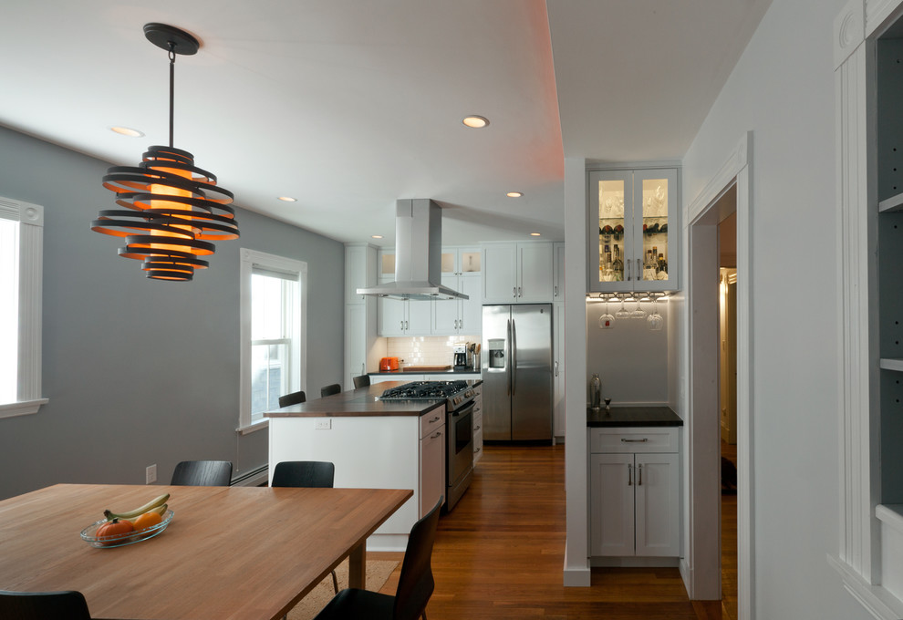 Immagine di una sala da pranzo aperta verso la cucina design con pareti grigie e parquet scuro