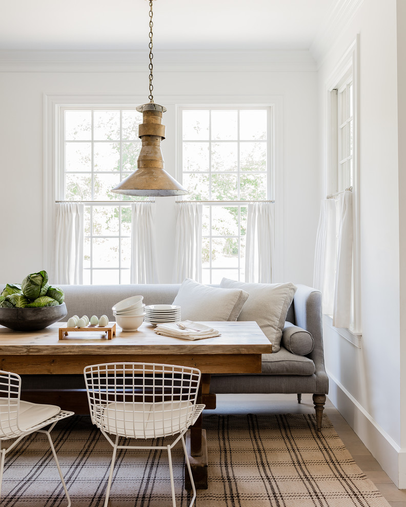 Dining room - coastal light wood floor dining room idea with white walls