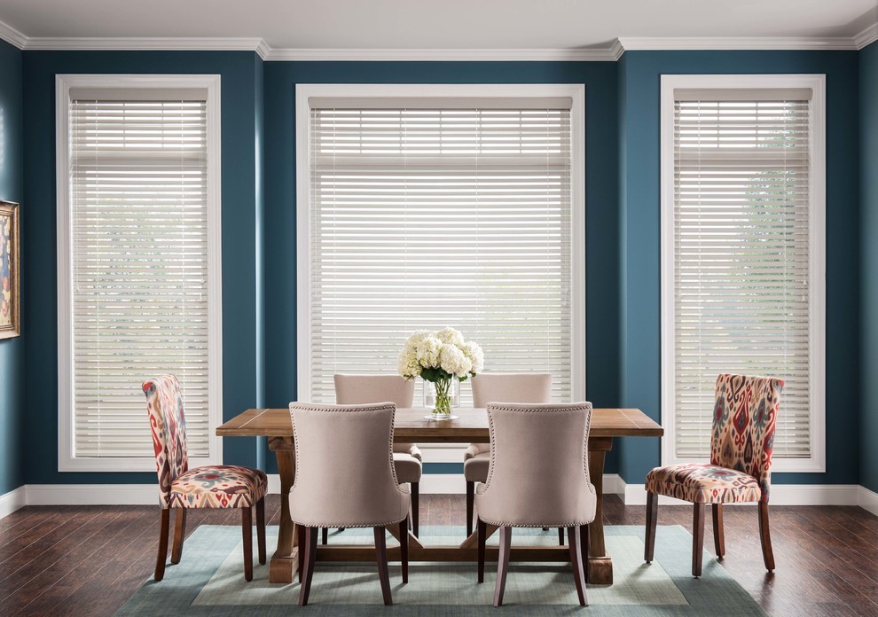 Пример оригинального дизайна: большая отдельная столовая в стиле неоклассика (современная классика) с синими стенами, паркетным полом среднего тона и коричневым полом без камина
