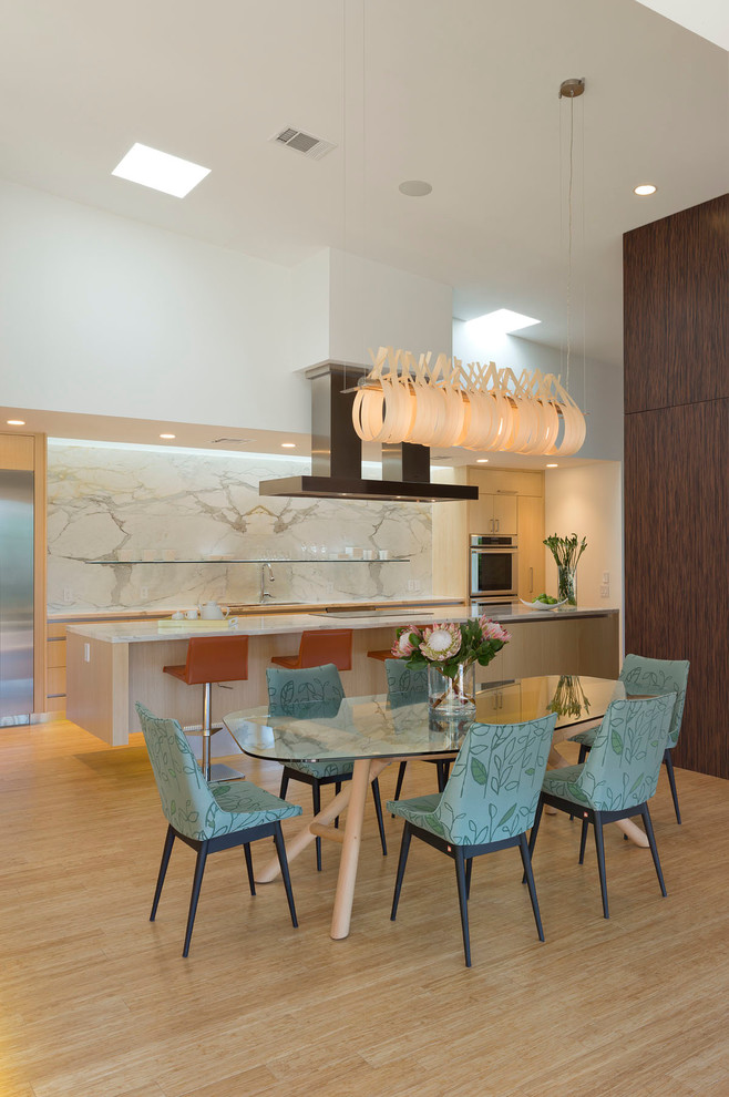 Moderne Wohnküche ohne Kamin mit weißer Wandfarbe und hellem Holzboden in Austin