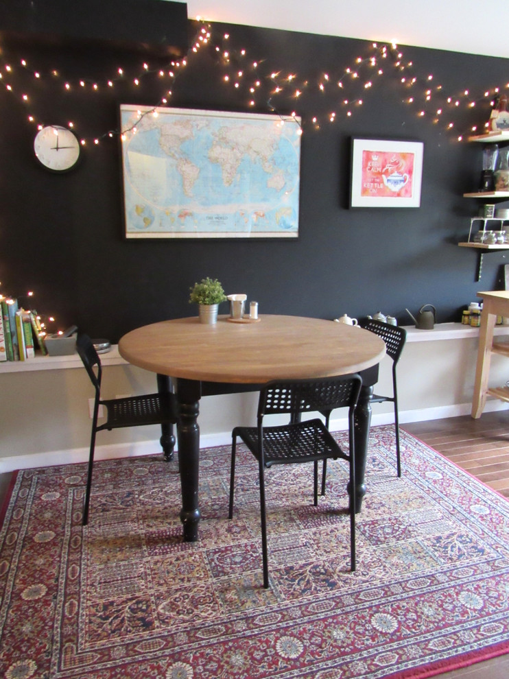 Small bohemian kitchen/dining room in San Francisco with black walls, dark hardwood flooring and no fireplace.