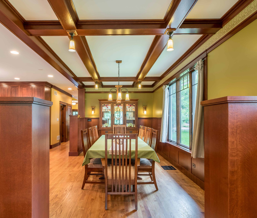 Mid-sized arts and crafts light wood floor, brown floor, coffered ceiling and wainscoting great room photo in Chicago with yellow walls and no fireplace