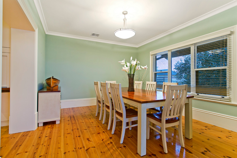 Immagine di una sala da pranzo aperta verso la cucina costiera di medie dimensioni con pareti verdi