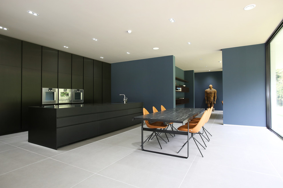 Immagine di una sala da pranzo aperta verso la cucina design con pareti blu