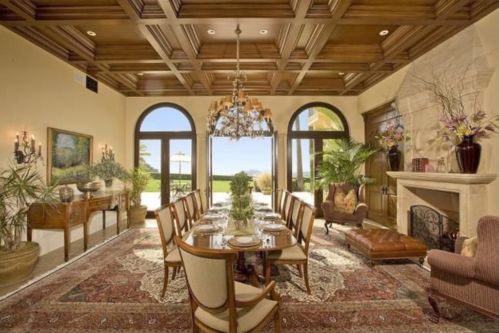 Пример оригинального дизайна: огромная гостиная-столовая в средиземноморском стиле с бежевыми стенами, стандартным камином, фасадом камина из камня, мраморным полом и коричневым полом