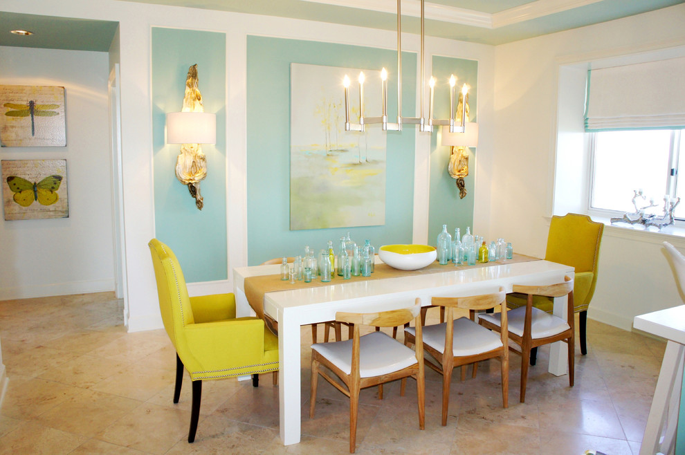Cette image montre une salle à manger ouverte sur le salon design de taille moyenne avec un mur bleu, un sol en travertin et aucune cheminée.