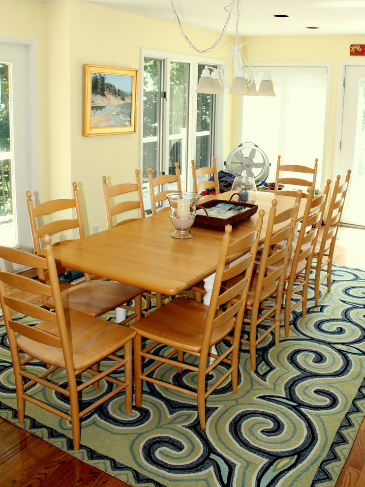 Foto di una grande sala da pranzo aperta verso la cucina stile marinaro con pareti gialle e parquet chiaro
