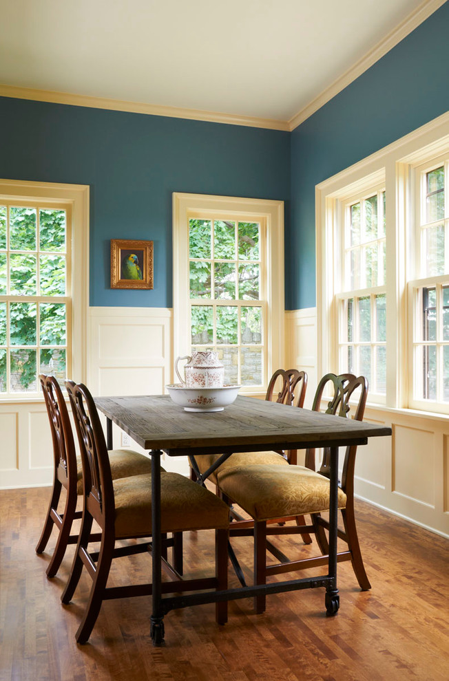 Elegant medium tone wood floor dining room photo in Minneapolis with blue walls