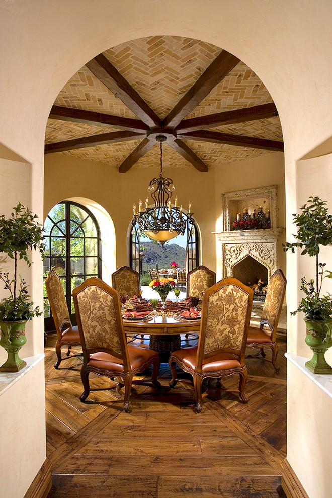 Cette image montre une très grande salle à manger traditionnelle fermée avec un mur beige, parquet foncé, une cheminée standard, un manteau de cheminée en pierre et un sol marron.