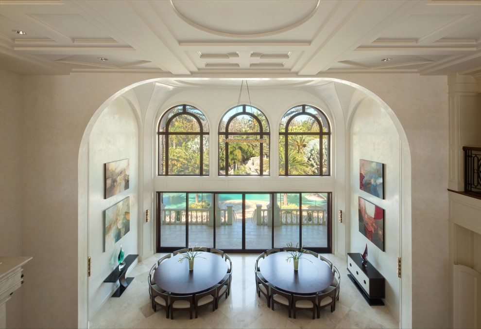 На фото: огромная гостиная-столовая в стиле неоклассика (современная классика) с белыми стенами, мраморным полом, стандартным камином и фасадом камина из плитки
