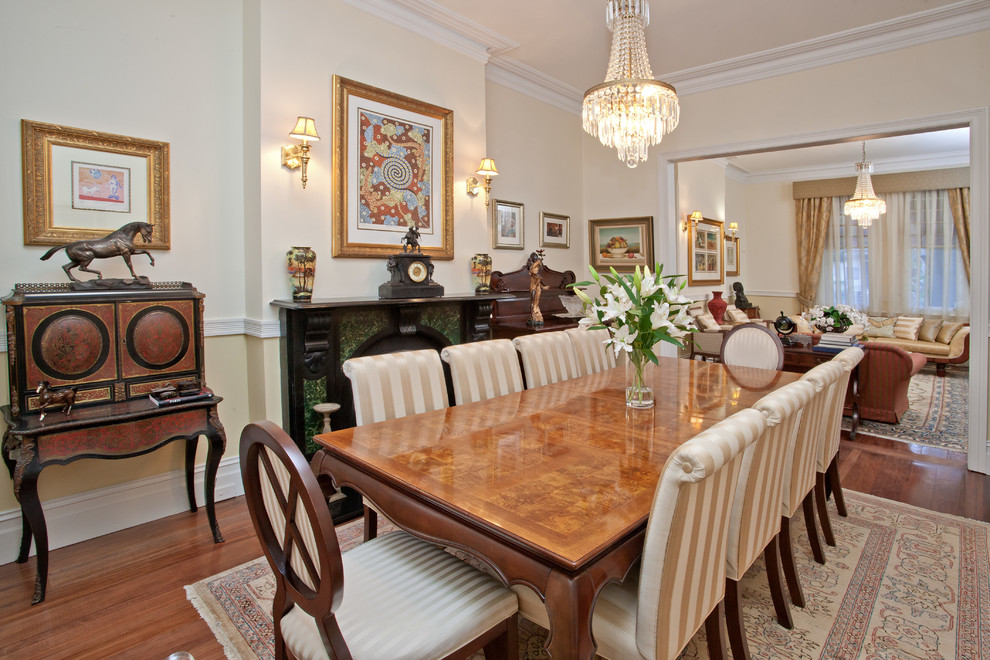 Aménagement d'une grande salle à manger classique avec parquet foncé, une cheminée standard et un manteau de cheminée en pierre.