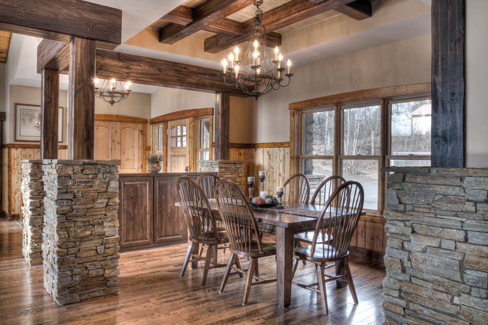 Cette photo montre une salle à manger ouverte sur le salon montagne de taille moyenne avec un mur beige, un sol en bois brun et aucune cheminée.