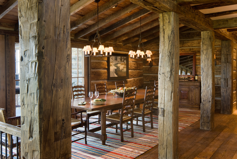 Inspiration for a rustic dining room in Other with a stone fireplace surround.