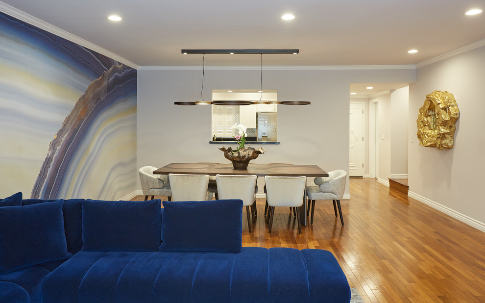 Offenes, Mittelgroßes Modernes Esszimmer mit blauer Wandfarbe, braunem Holzboden, Eckkamin, Kaminumrandung aus Stein und buntem Boden in Los Angeles
