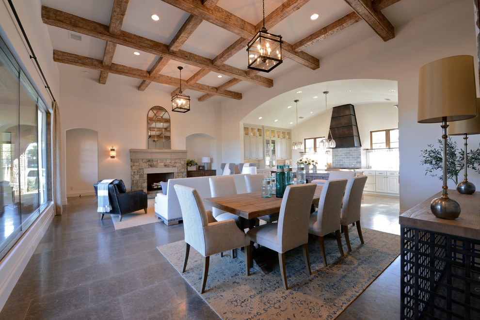 Foto di un'ampia sala da pranzo tradizionale con pareti bianche, pavimento in pietra calcarea, camino classico e cornice del camino in pietra
